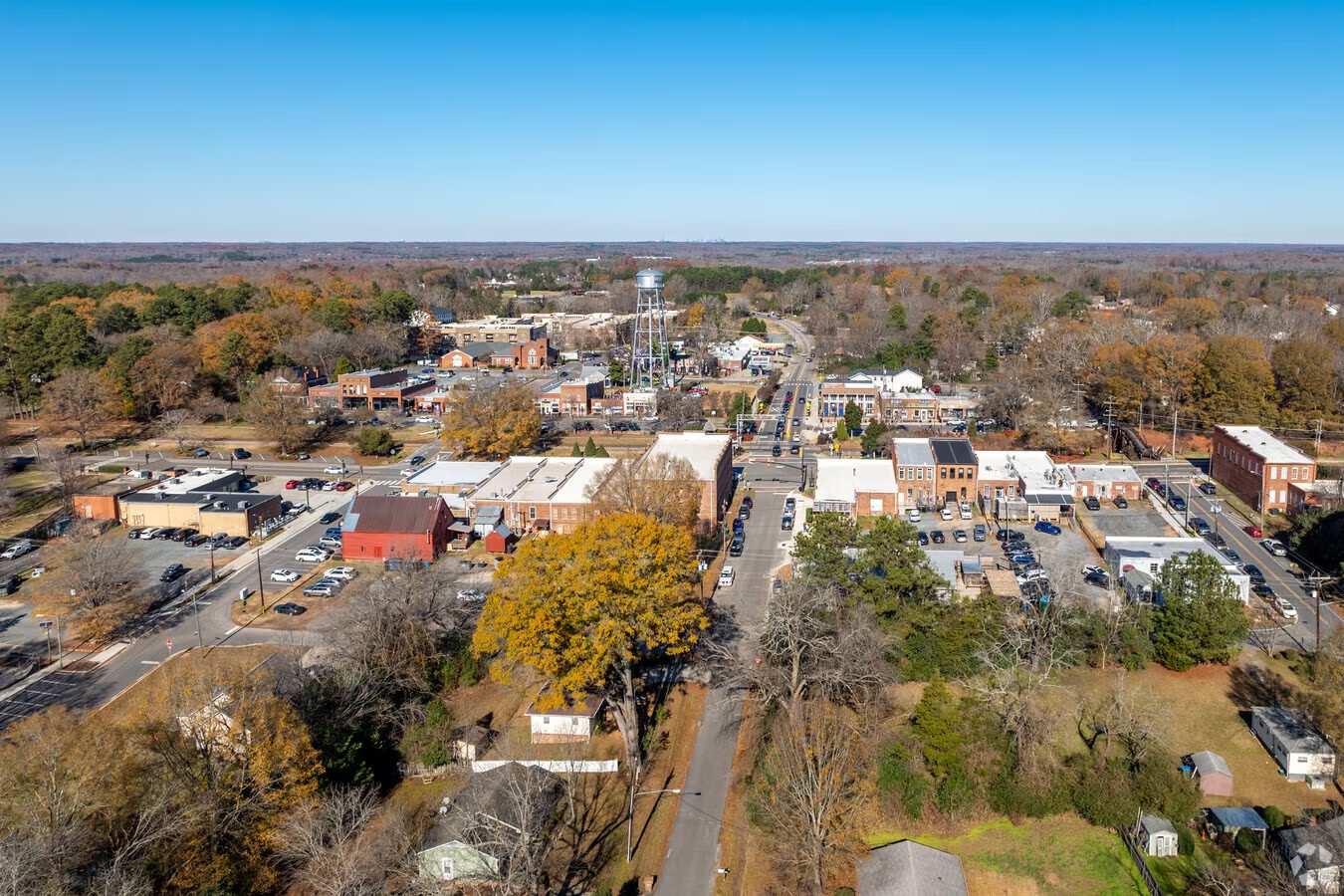 Aerial view of a small-town main street and surrounding tree cover in the Charlotte area