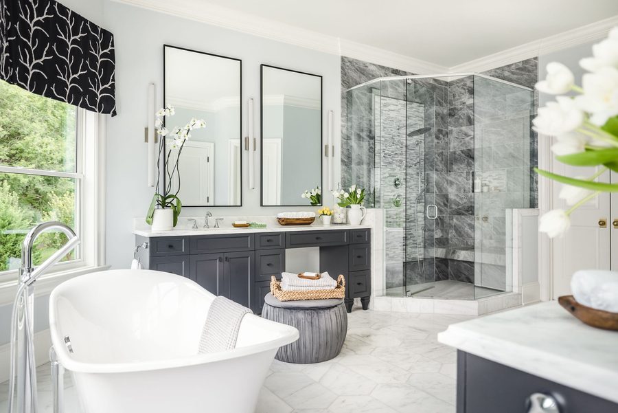 Primary bath with a freestanding tub, marble-tiled shower, and a double vanity