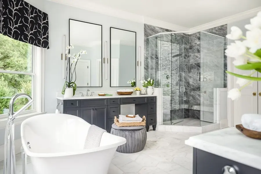 Primary bath with a freestanding tub, marble-tiled shower, and a double vanity