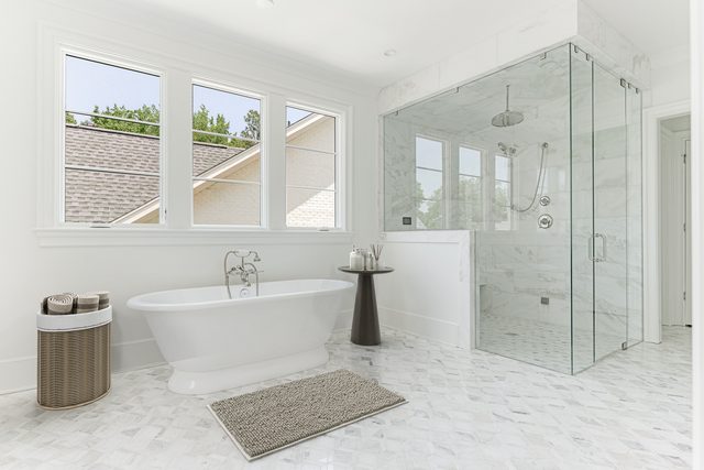 Sterling custom home in Myers Park: primary bath with freestanding tub and glass-enclosed marble shower
