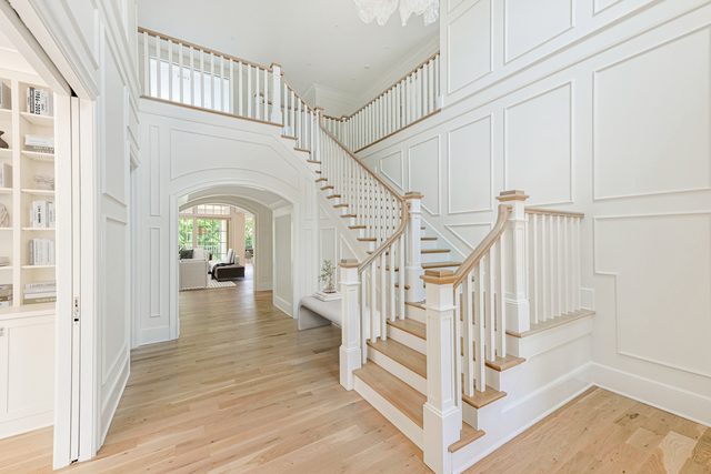 Sterling custom home in Myers Park: entry hall with paneled walls, staircase and light wood floors