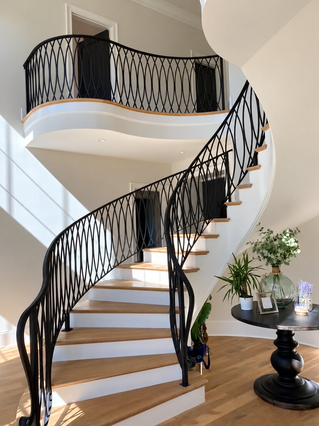 Curved staircase with a black iron railing and white oak treads in a finished Everett Custom Homes build